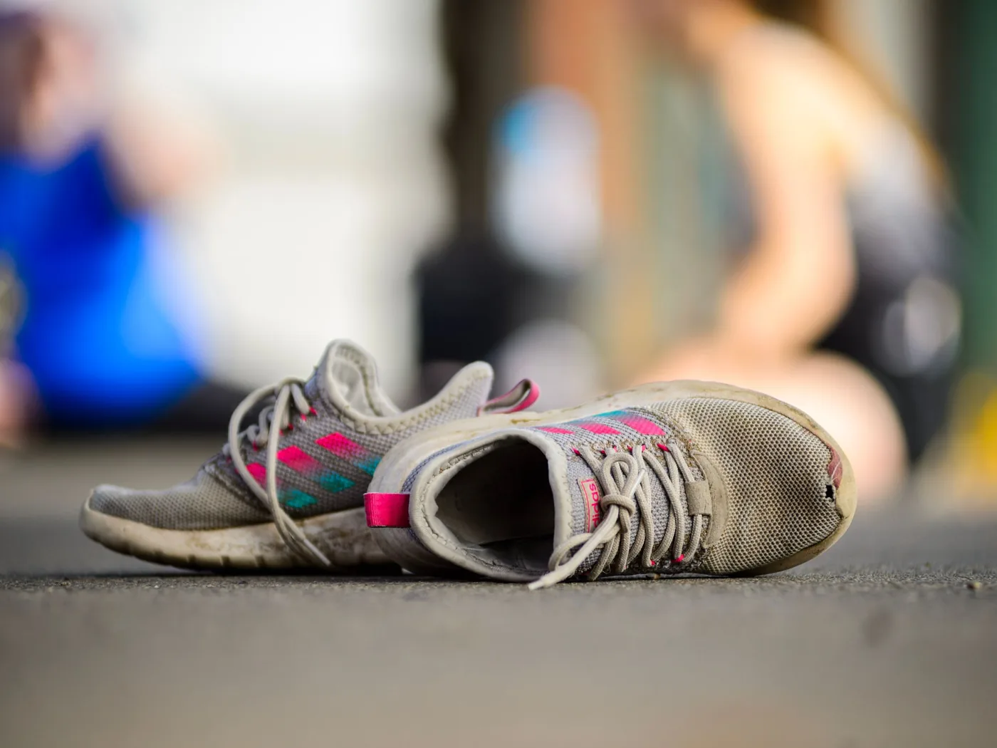 Paire de chaussures de course usées posée au sol, à apporter au magasin